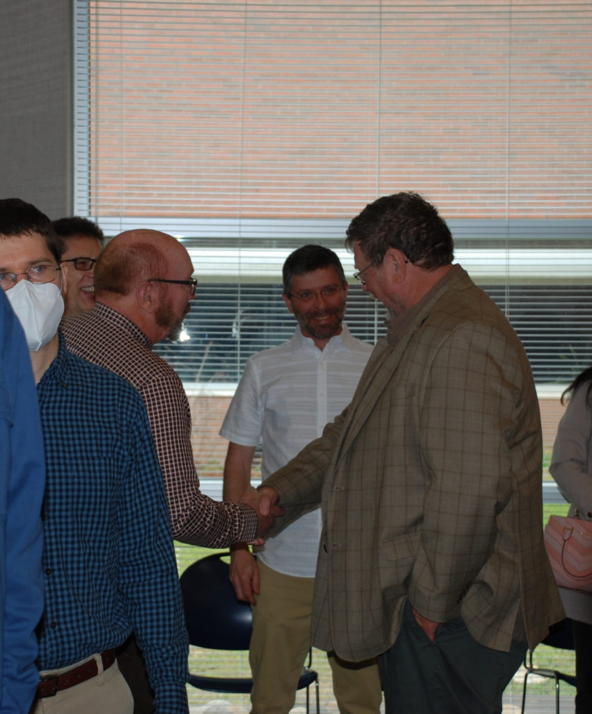 Burt English reminiscing with colleagues at retirement reception in his honor