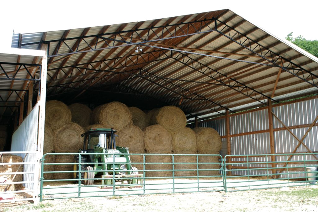 Round bales of hay stacked in barn