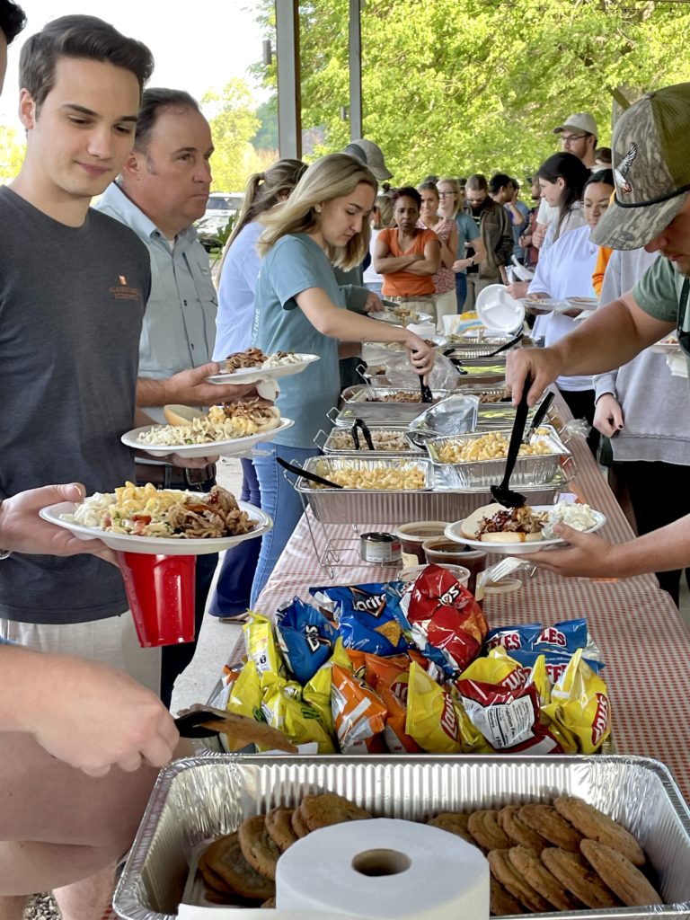 Student, faculty and staff getting food at the department picnic