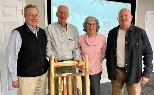 Kevin Ferguson, Dallas Manning, his wife and Keith Carver standing with Dallas's retirement gift of a Tennessee woods rocking chair.