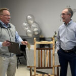 Kevin Ferguson presenting plaque and rocking chair to Alan Galloway on his retirement