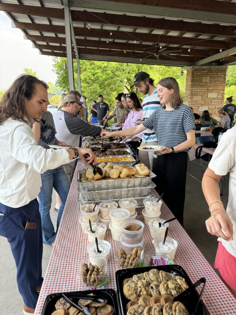 Students, faculty and staff getting food at the spring picnic